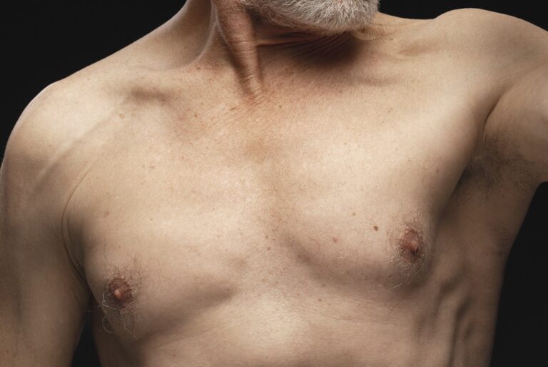 senior man chest close up in black background